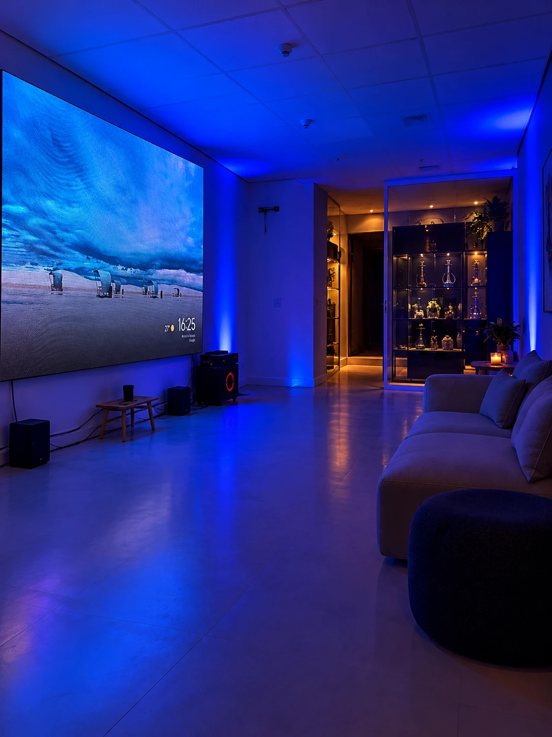 Lounge com sofá, painel LED e luz baixa